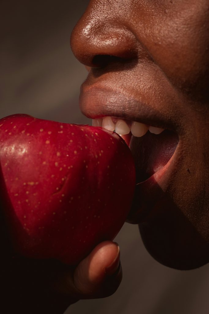 A woman biting an apple