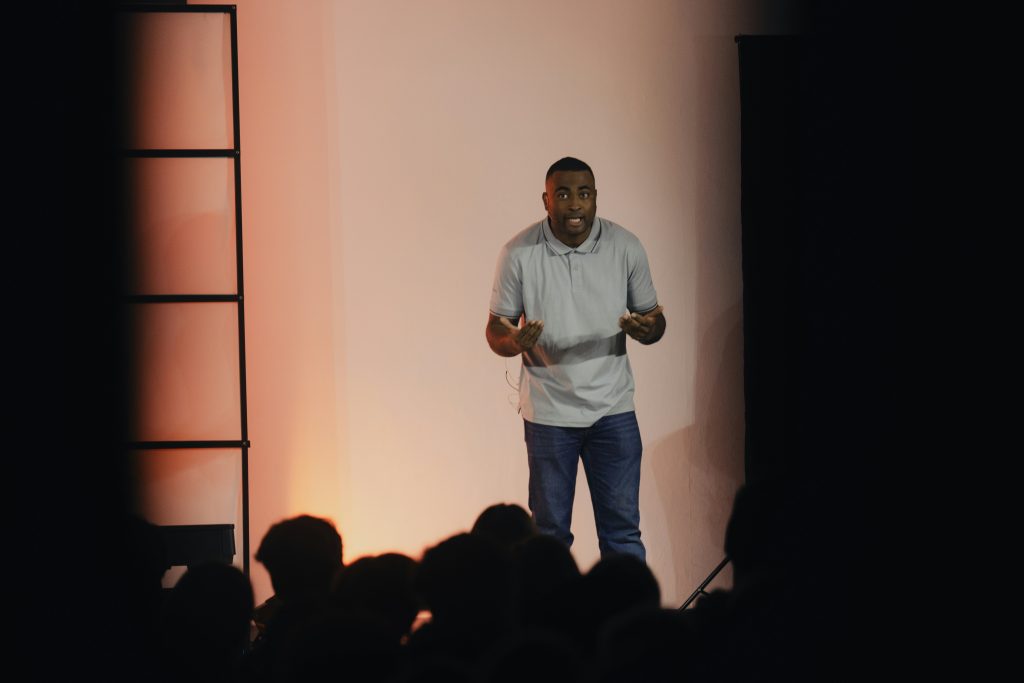 A man telling the crowd his business journey