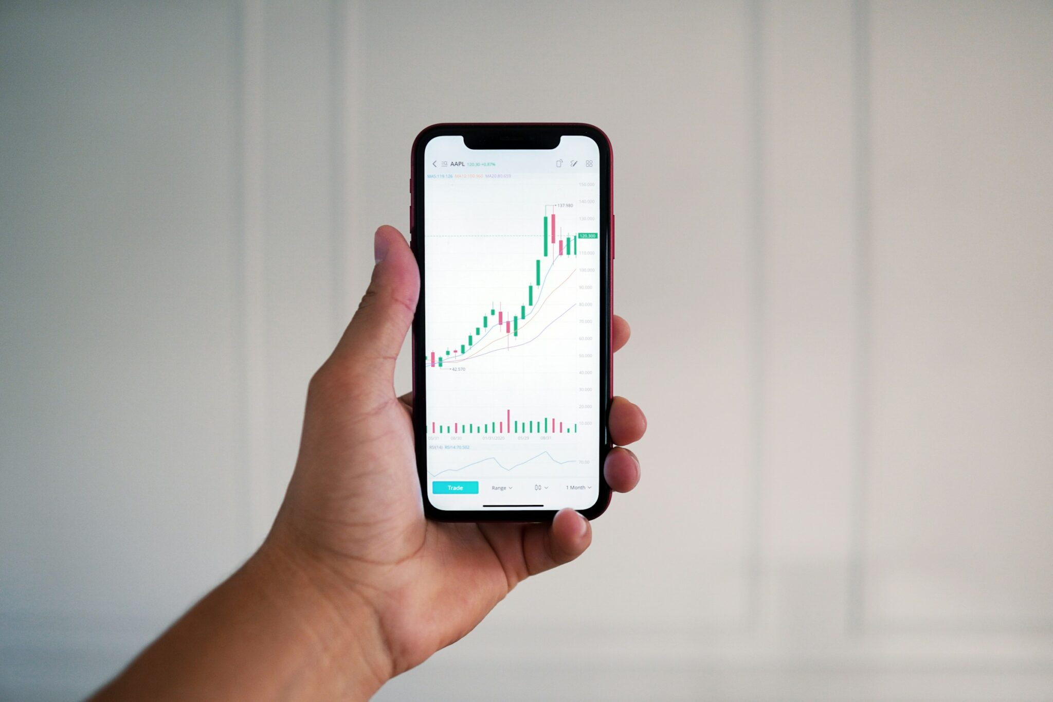 A hand holding a phone to track NGX trading progress