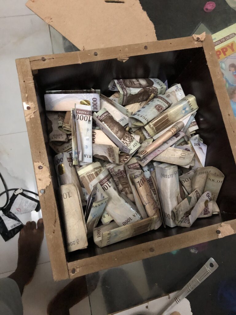 A box of naira notes saved over few months - how to save money fast in Nigeria