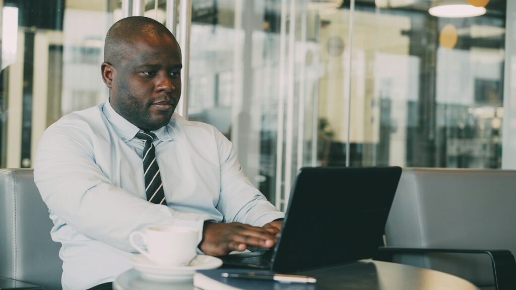A man looking at the stocks chart on a laptop - Brewery stocks in Nigeria